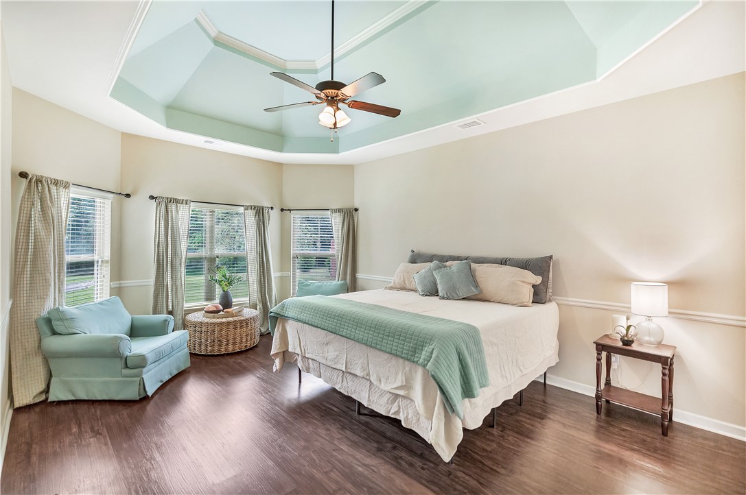 144 Buckland Drive Anderson, SC 29621 - Photo 4 of 48 Hardwood floors and a tray ceiling with a fan define this inviting primary bedroom retreat.