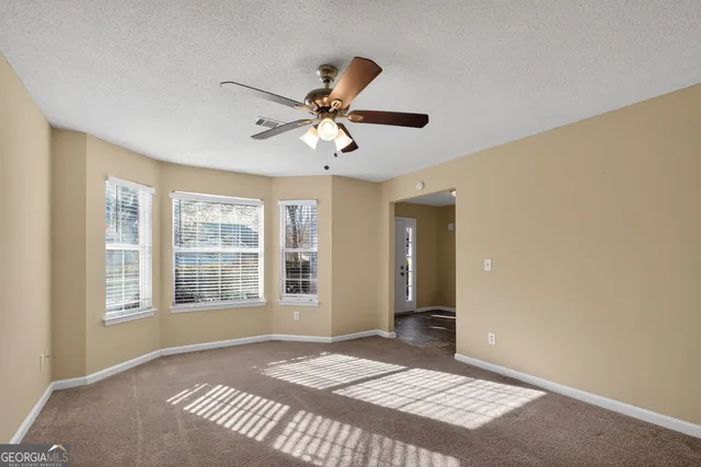 a view of a room with a ceiling fan and a window