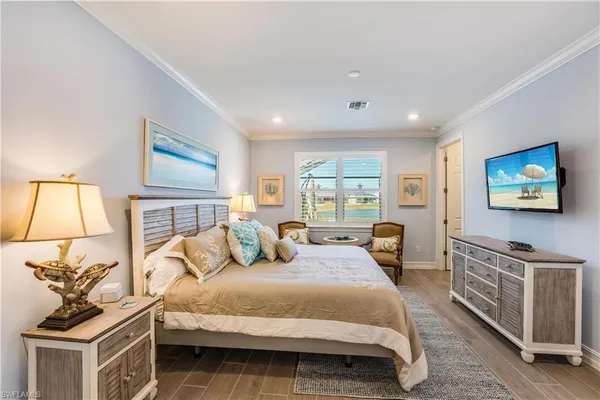 a bedroom with a bed a dresser and next to a window