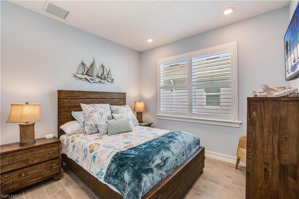 14471 Stillwater Way Naples, FL 34114 - Photo 12 of 20 a bedroom with a bed a dresser and next to a window