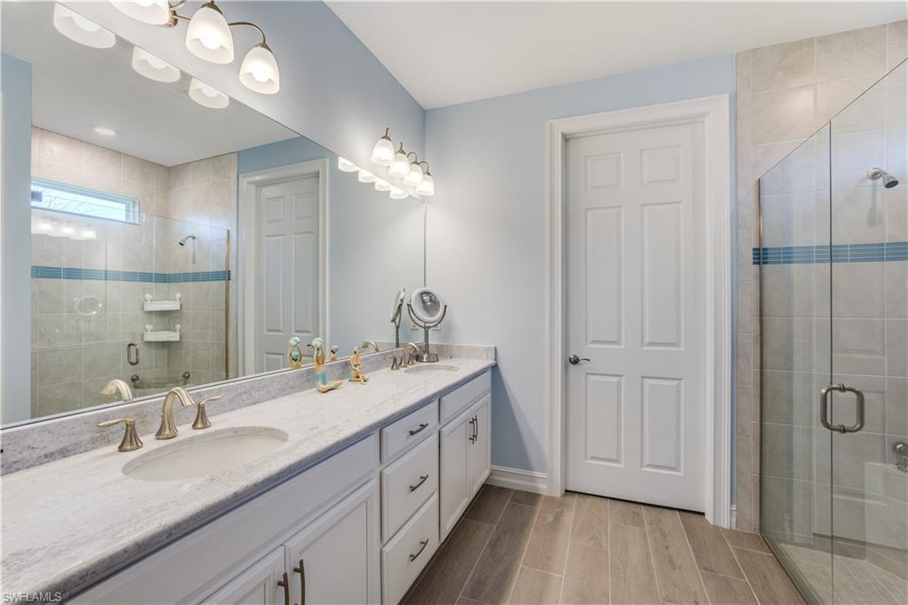 14471 Stillwater Way Naples, FL 34114 - Photo 14 of 20 a spacious bathroom with a double vanity sink a large mirror and shower