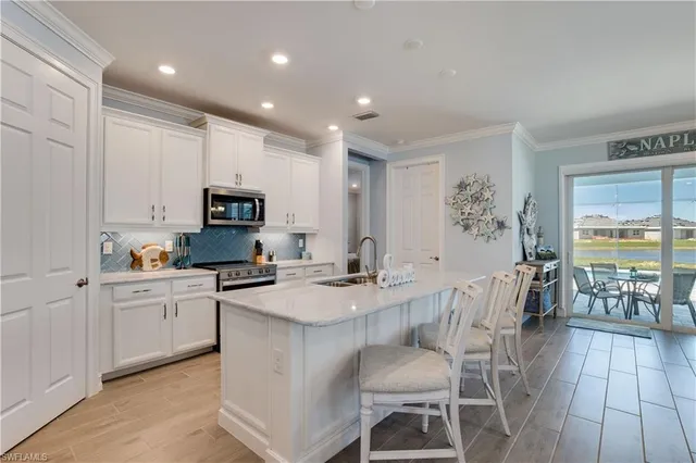 a kitchen with stainless steel appliances granite countertop a stove top oven a sink dishwasher a dining table and chairs with wooden floor