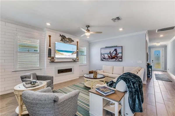 a living room with furniture a flat screen tv and a fireplace