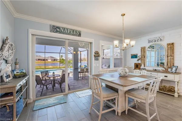 a view of a dining room and livingroom with furniture wooden floor a chandelier