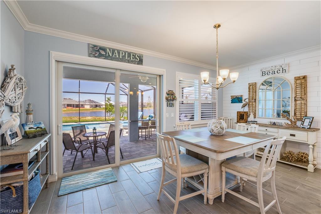14471 Stillwater Way Naples, FL 34114 - Photo 9 of 20 a view of a dining room and livingroom with furniture wooden floor a chandelier