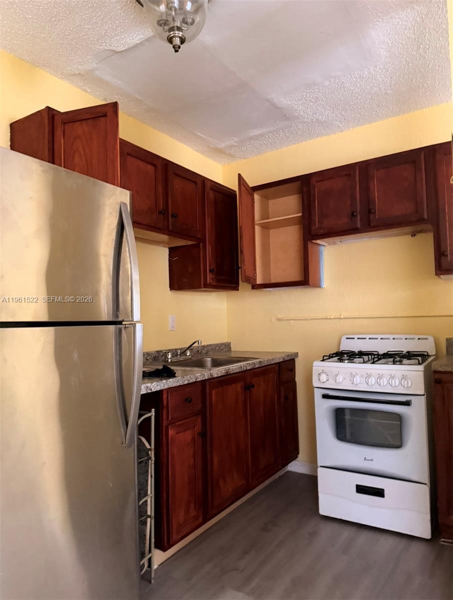 3615 Thomas Avenue, Unit 3 Miami, FL 33133 - Photo 2 of 12 a kitchen with stainless steel appliances a stove a refrigerator and a sink