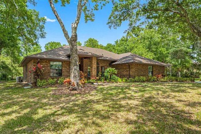 a backyard of a house with table and chairs under an umbrella