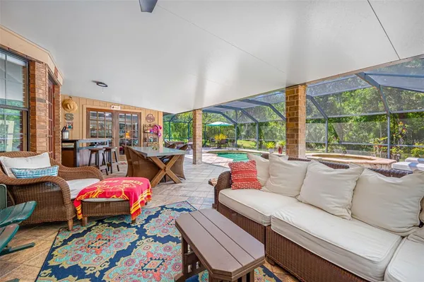 a living room with patio furniture and a wooden floor