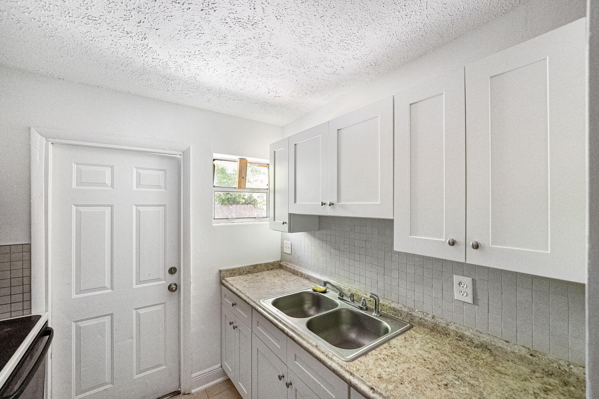 2108 Avenue East Fort Pierce, FL 34950 - Photo 19 of 32 a kitchen with white cabinets sink and dishwasher