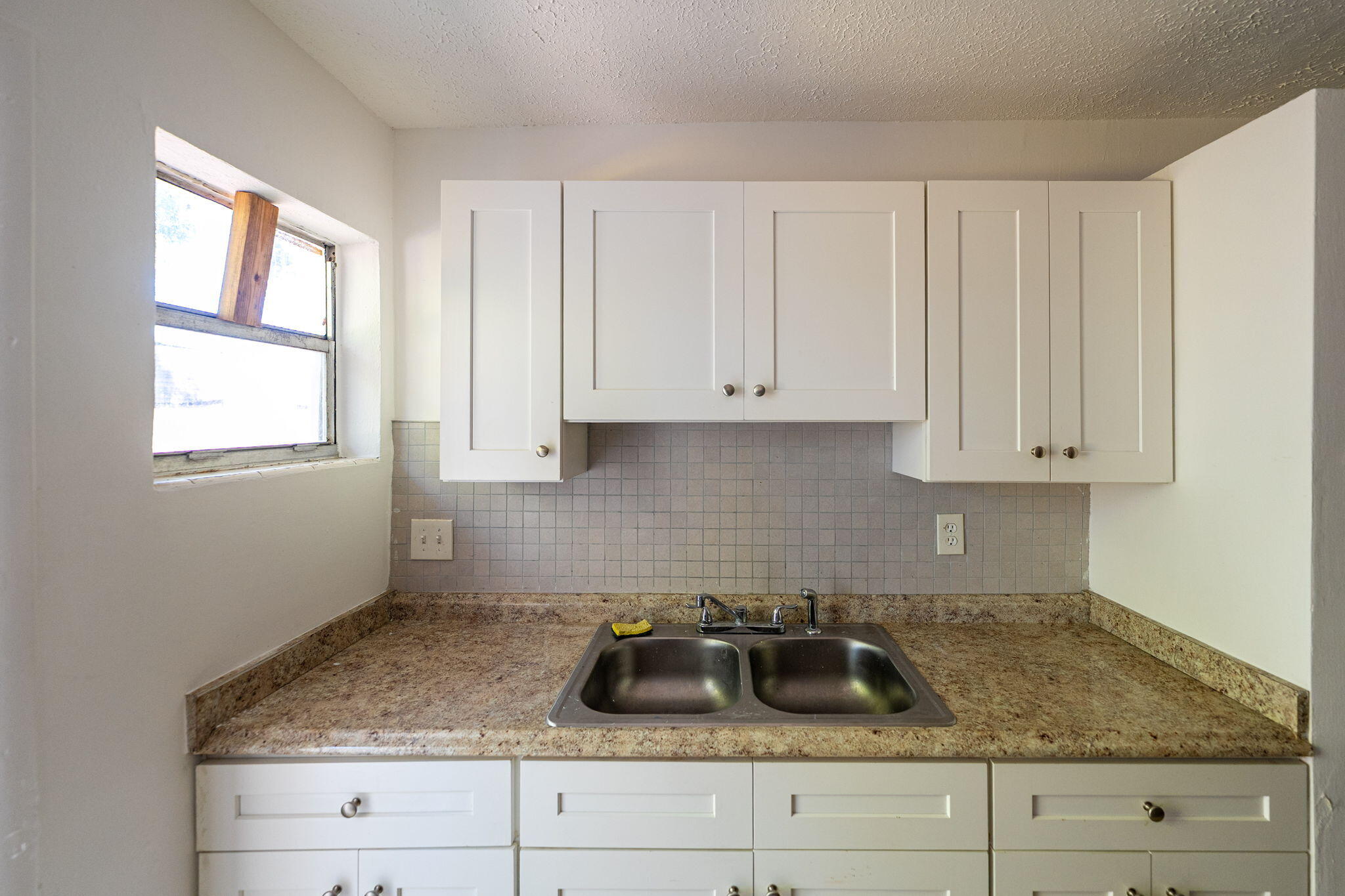 2108 Avenue East Fort Pierce, FL 34950 - Photo 21 of 32 a kitchen with granite countertop white cabinets and white sink