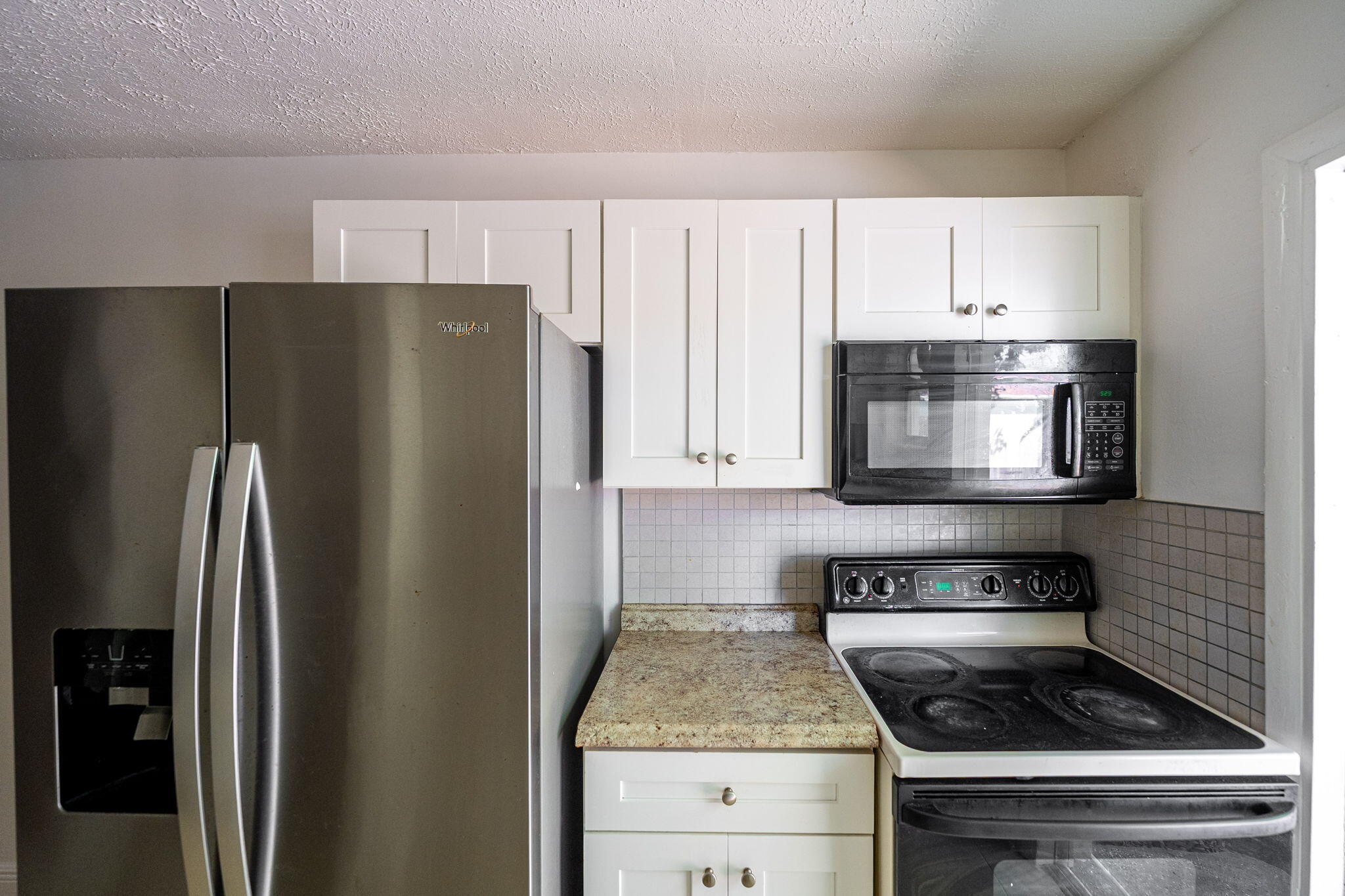 2108 Avenue East Fort Pierce, FL 34950 - Photo 22 of 32 a kitchen with white cabinets and stainless steel appliances