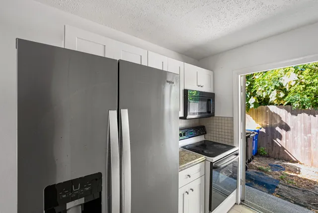 a kitchen with stainless steel appliances granite countertop a refrigerator and a stove