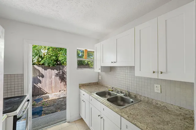 a kitchen with a sink stove top oven and cabinets