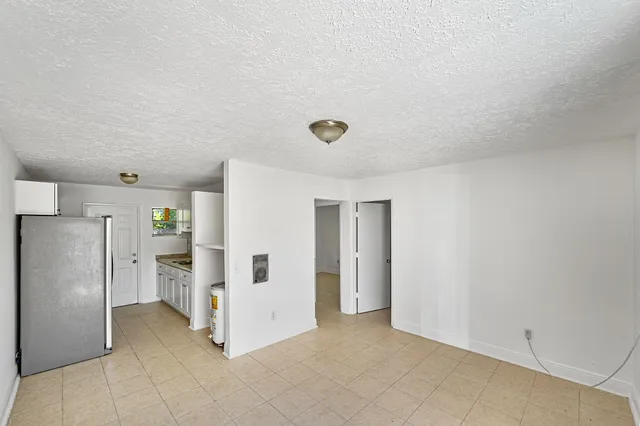 a view of a refrigerator in kitchen and white cabinets