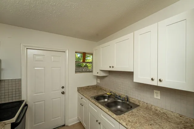 a kitchen with white cabinets and a stove top oven