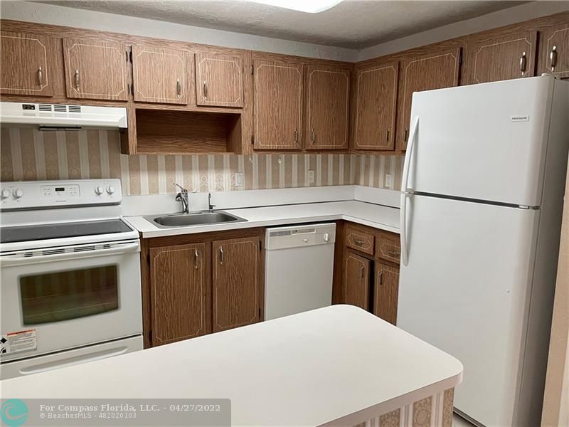 a kitchen with a sink a stove a refrigerator and cabinets
