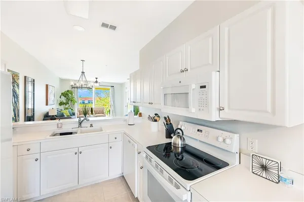a kitchen with white cabinets and white appliances