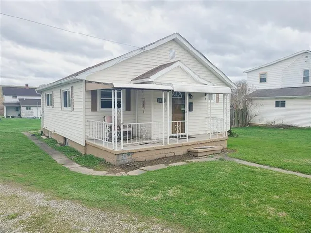 a view of a house with a yard and sitting area