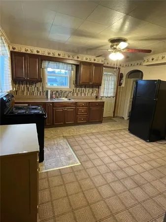 a kitchen with stainless steel appliances kitchen island granite countertop a refrigerator and a stove top oven