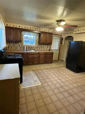 a kitchen with stainless steel appliances kitchen island granite countertop a refrigerator and a stove top oven