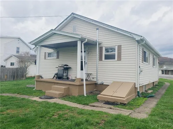 a view of a white house and a yard with table and chairs in a yard