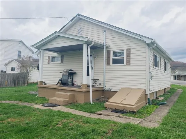 a view of a white house and a yard with table and chairs in a yard