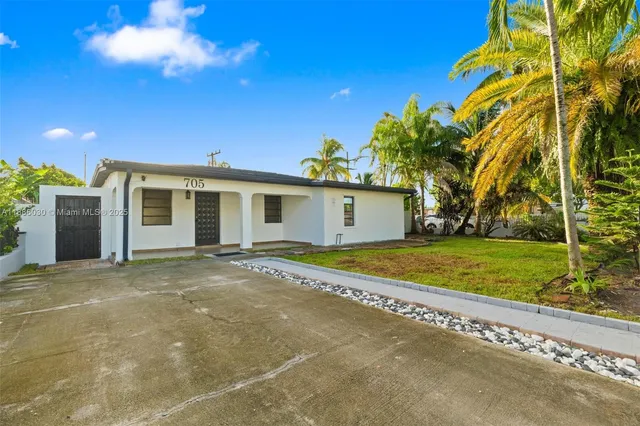 a view of a house with a backyard and a tree