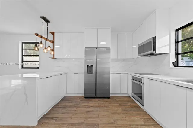 a kitchen with stainless steel appliances granite countertop a refrigerator and a sink