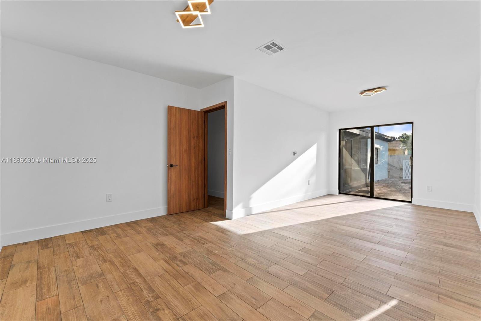 705 East 9th Lane Hialeah, FL 33010 - Photo 21 of 37 a view of an empty room with wooden floor and a window