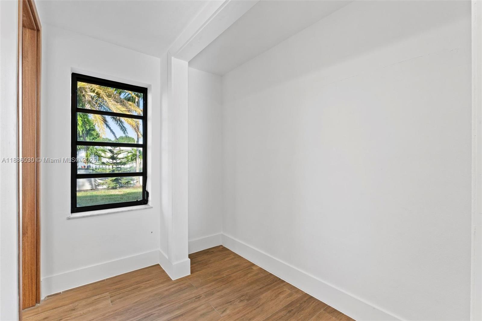 705 East 9th Lane Hialeah, FL 33010 - Photo 24 of 37 an empty room with wooden floor and windows