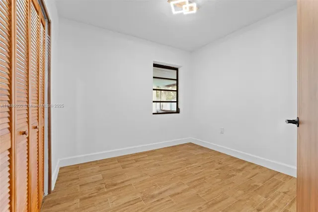 an empty room with wooden floor and closet
