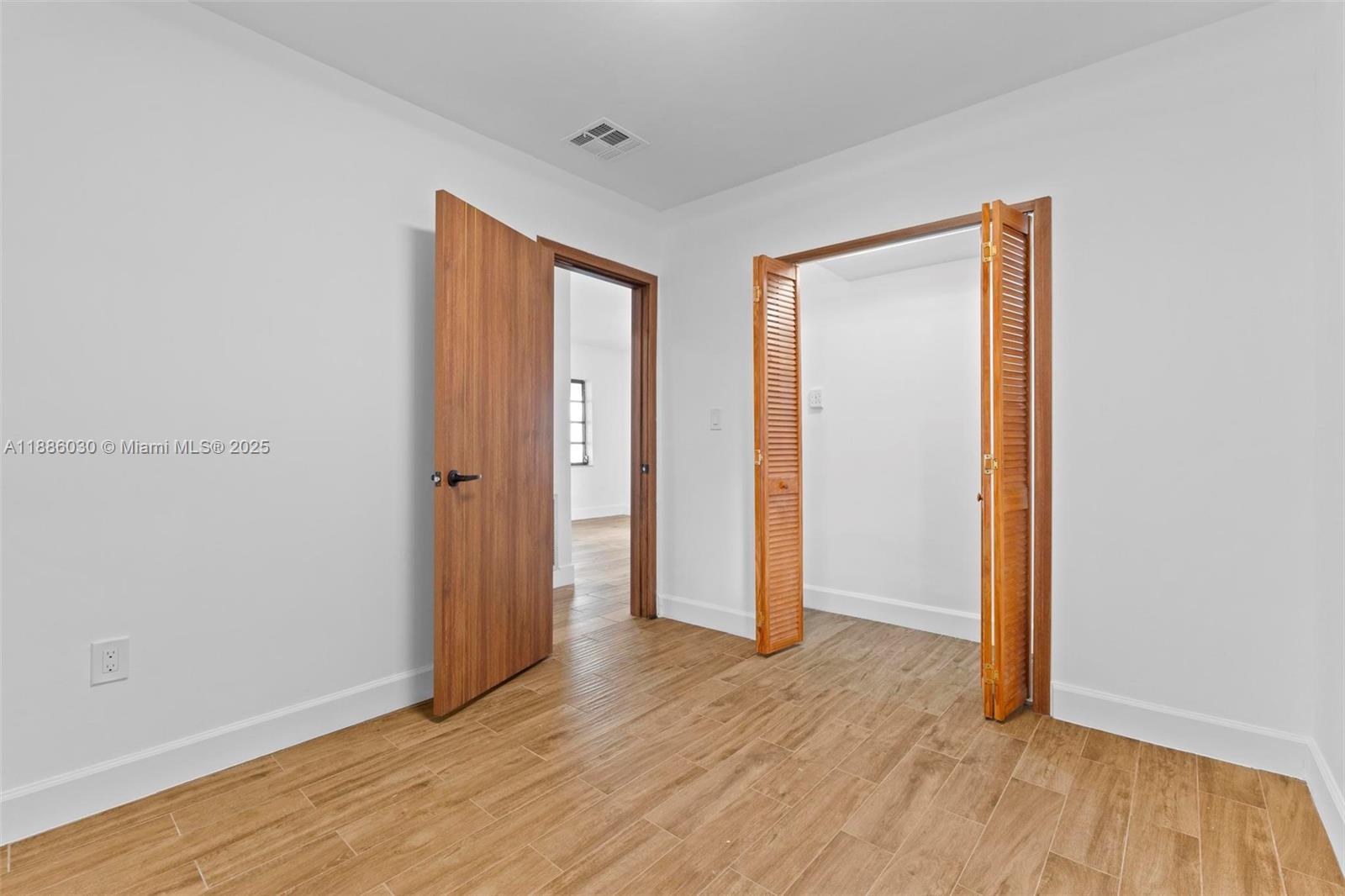 705 East 9th Lane Hialeah, FL 33010 - Photo 27 of 37 an empty room with wooden floor and closet