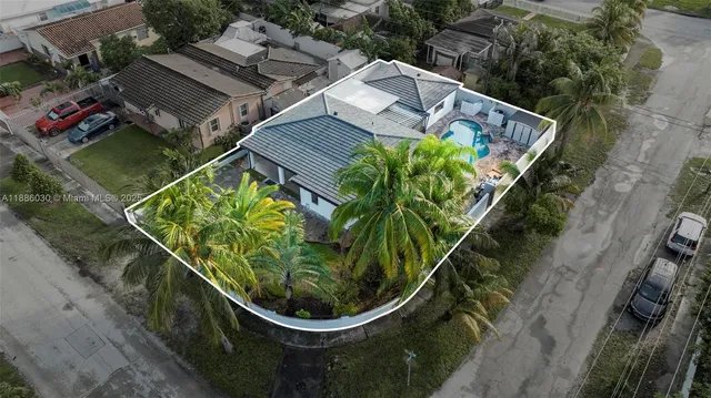an aerial view of a house with a yard and wooden fence