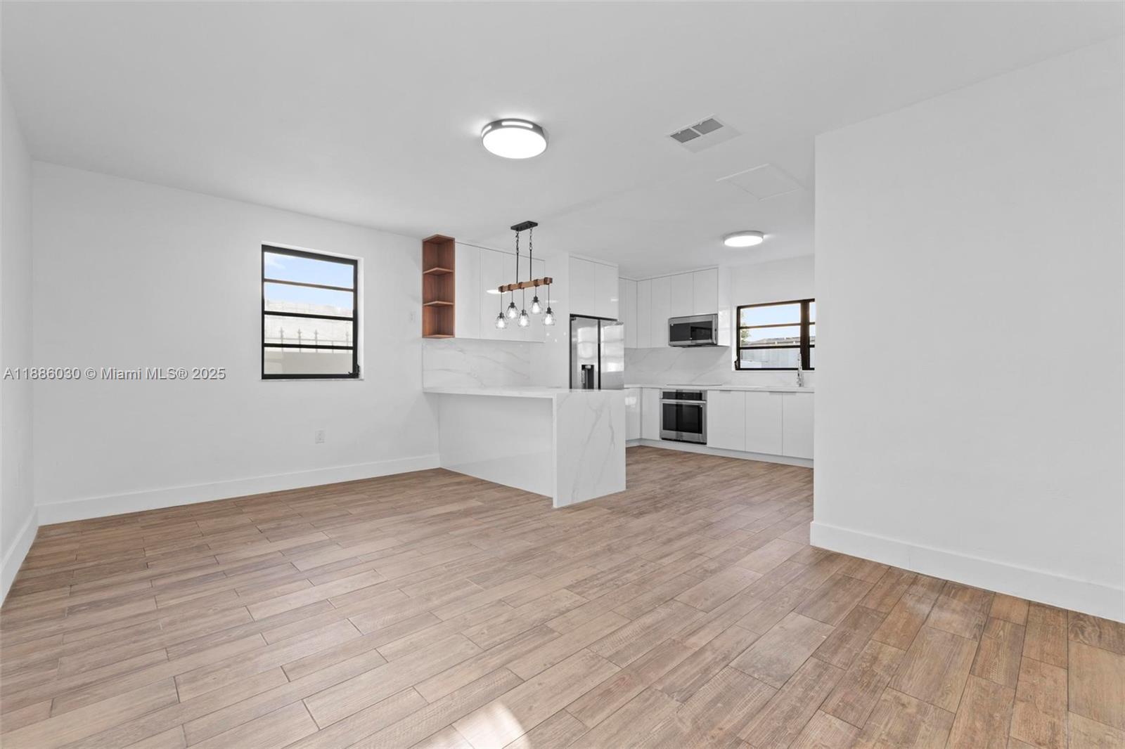 705 East 9th Lane Hialeah, FL 33010 - Photo 9 of 37 a view of a kitchen with wooden floor electronic appliances and windows