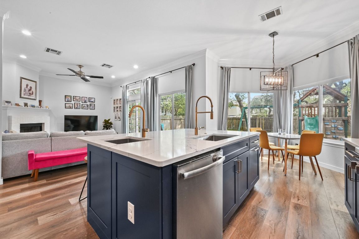 6609 Oasis Drive Austin, TX 78749 - Photo 14 of 27 a kitchen with a stove a sink dishwasher and a dining table with wooden floor