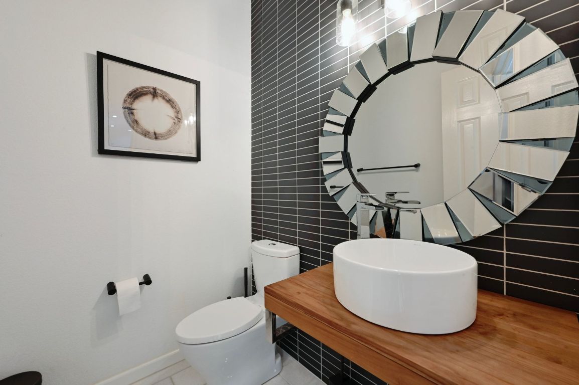 6609 Oasis Drive Austin, TX 78749 - Photo 17 of 27 a bathroom with a toilet a sink and mirror