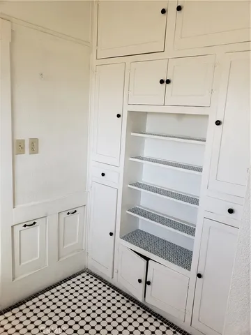a walk in closet with white cabinets