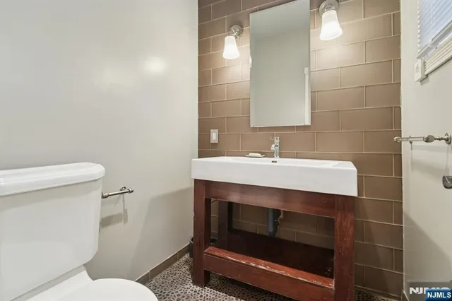 a bathroom with a sink toilet and a mirror