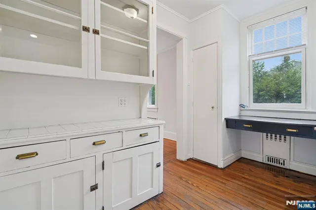 a view of white cabinets with wooden floor