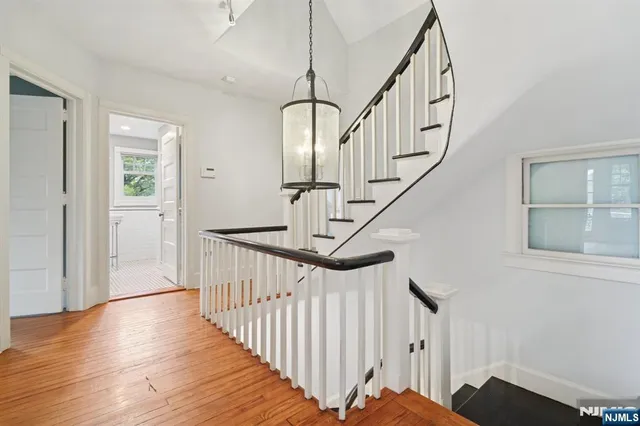 a view of staircase with wooden floor and white walls