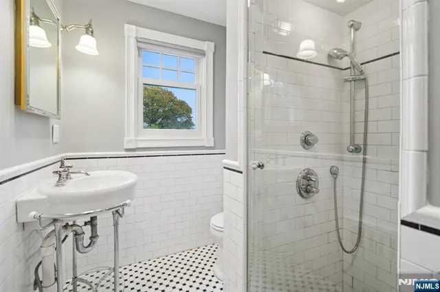 a bathroom with a sink shower and a mirror