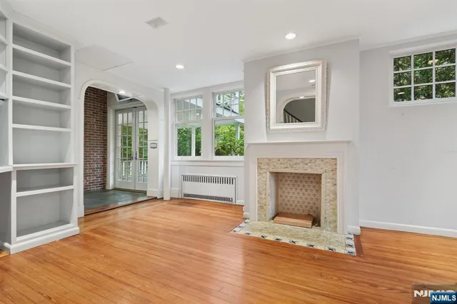 a view of an empty room with a fireplace and a window