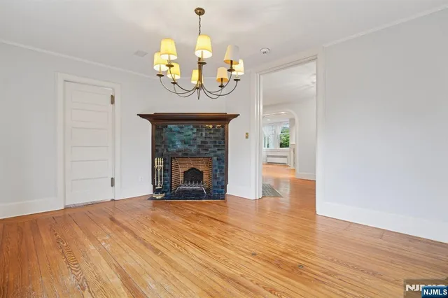 a view of a livingroom with a fireplace a chandelier and wooden floor