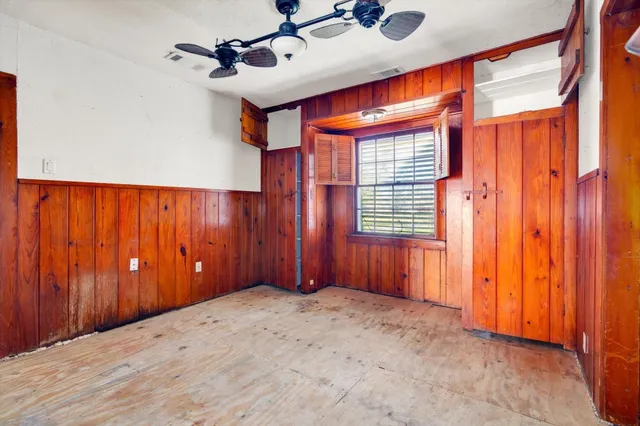a view of a yard with large tree and wooden fence