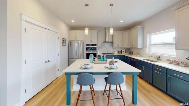 a kitchen with stainless steel appliances kitchen island granite countertop a sink refrigerator and cabinets