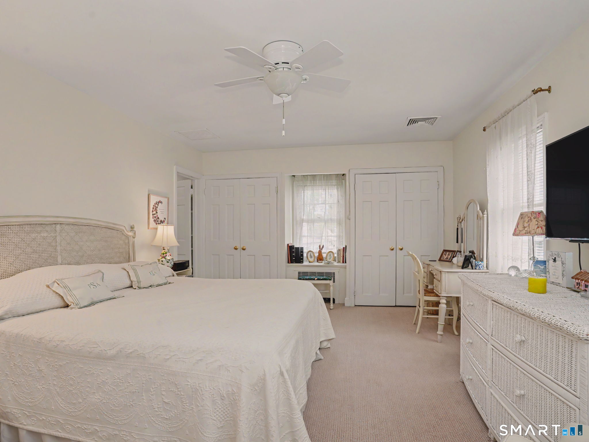 20 Chelsea Street Fairfield, CT 06824 - Photo 16 of 28 a large bedroom with a bed and a flat tv screen on dresser