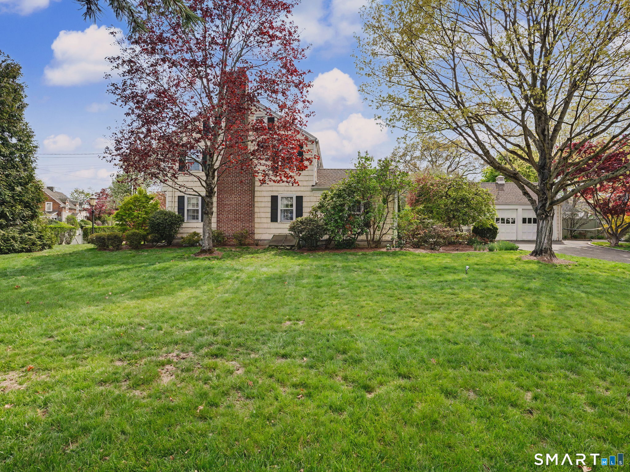 20 Chelsea Street Fairfield, CT 06824 - Photo 25 of 28 a view of a house with a big yard and large trees