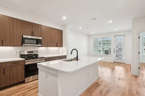 a large kitchen with a sink and refrigerator