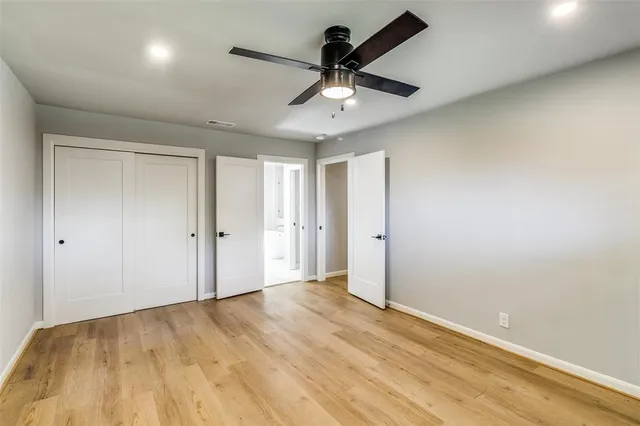 a view of an empty room and chandelier fan