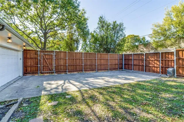 a view of backyard with wooden fence